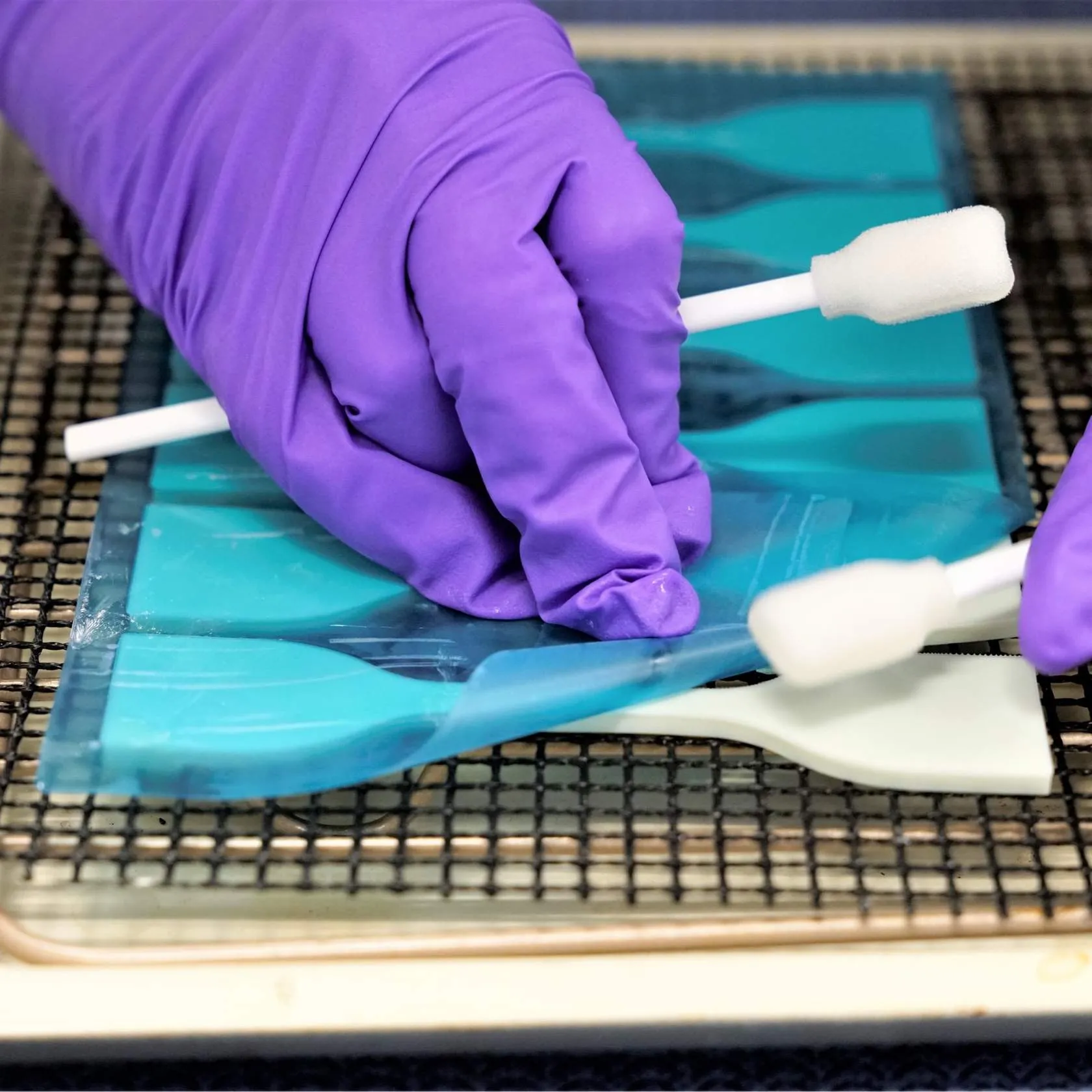 Film peeled off of parts on baking setup, using swabs to assist for minimal handling.